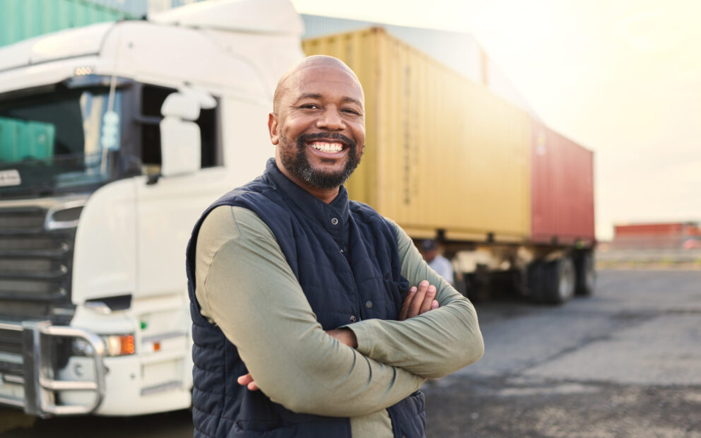Truck driver smiles in front of his rig.