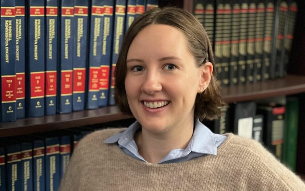 Headshot of woman smiling against backdrop of legal bookcase