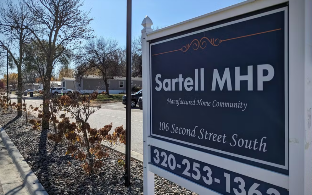 Mobile home park in background, in foreground is sign that reads Sartell MHP with view of phone number 320-253-1363.