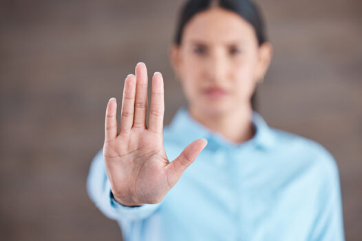 Closeup hand of a woman gesturing stop while standing in her office.