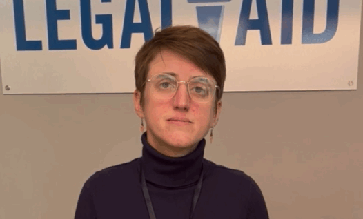 woman standing in front of a logo for Mid-Minnesota Legal Aid