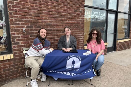 three people sitting at a table outside