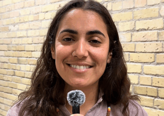 woman smiling, holding a microphone