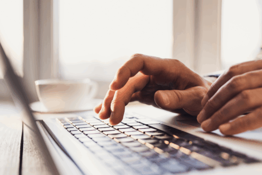 hands typing on laptop