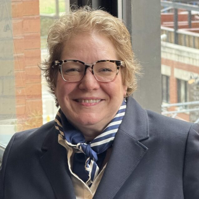 Individual i navy blue blazer, kerchief, glasses and sandy brown hair