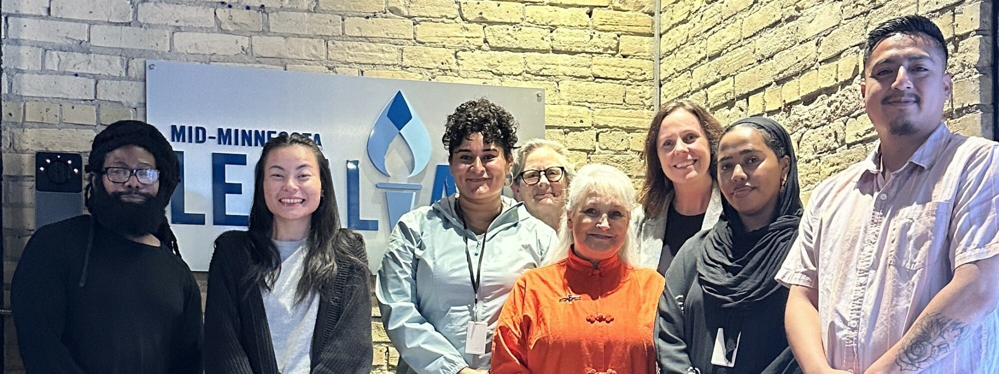 group of people standing in front of brick wall