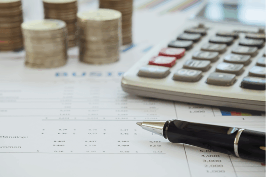 coins and a calculator on top of a spreadsheet