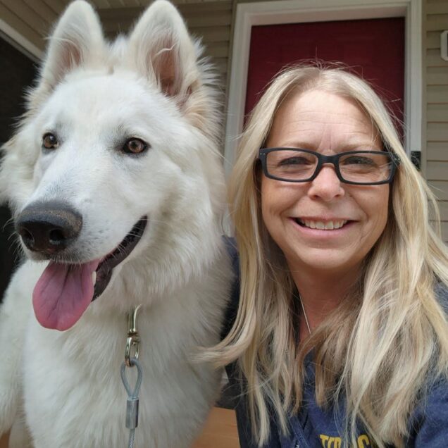 woman sitting next to dog