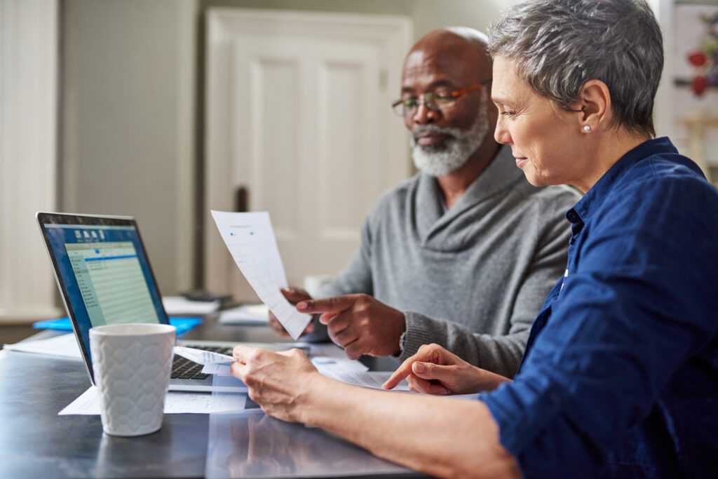 Laptop and documents with a senior couple.