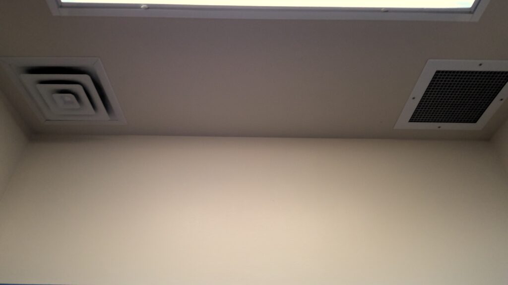 Ceiling diffuser vent, grated vent, and recessed lighting.