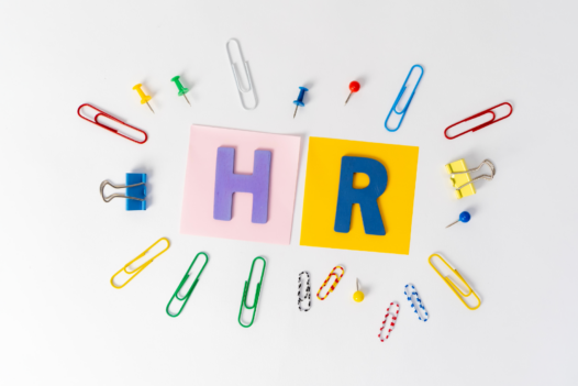 HR written on sticky notes, surrounded by paperclips