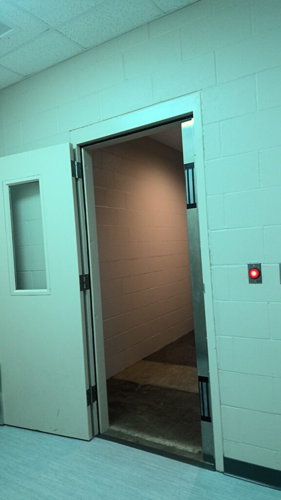 Open door with glowing red light on adjacent wall.