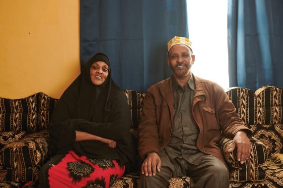 man and woman sit on a couch