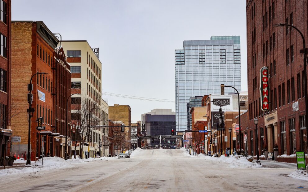 Long shot of Minneapolis city street, viewing both sides of business, shop district from middle of road that is snow dusted in Minneapolis North Loop