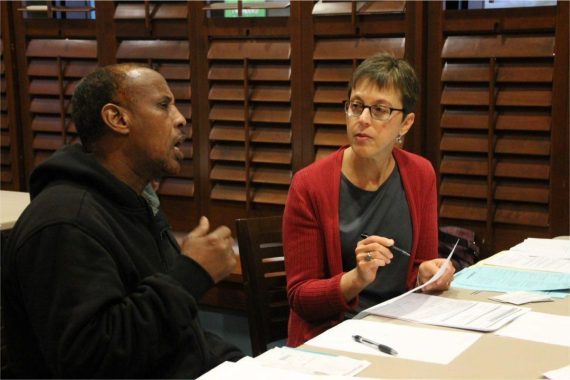 man and woman sitting at a table with documents