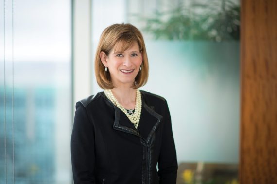 woman wearing a suit standing in front of glass walls