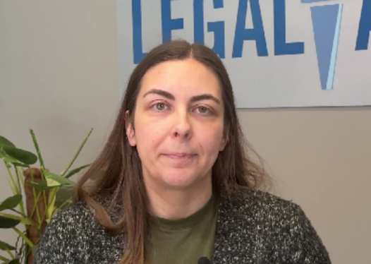 woman standing in front of legal aid logo