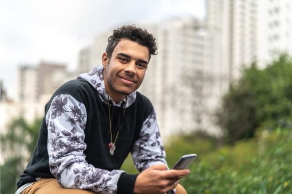 man sitting holding a phone