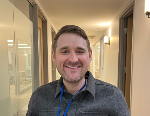 person smiling in a hallway