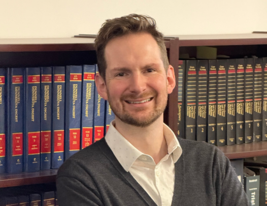 person standing in front of a bookshelf